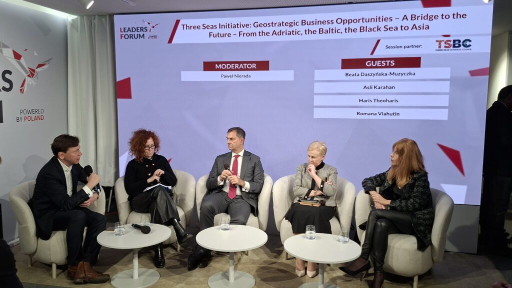 A group of panelists seated at a conference table during a discussion on the Three Seas Initiative at the Leaders Forum in Davos 2026. Participants are engaged in conversation, with microphones and nameplates visible, against a backdrop featuring the event’s branding.